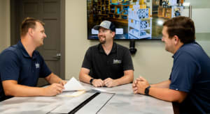 KaTom employees sitting at table in meeting