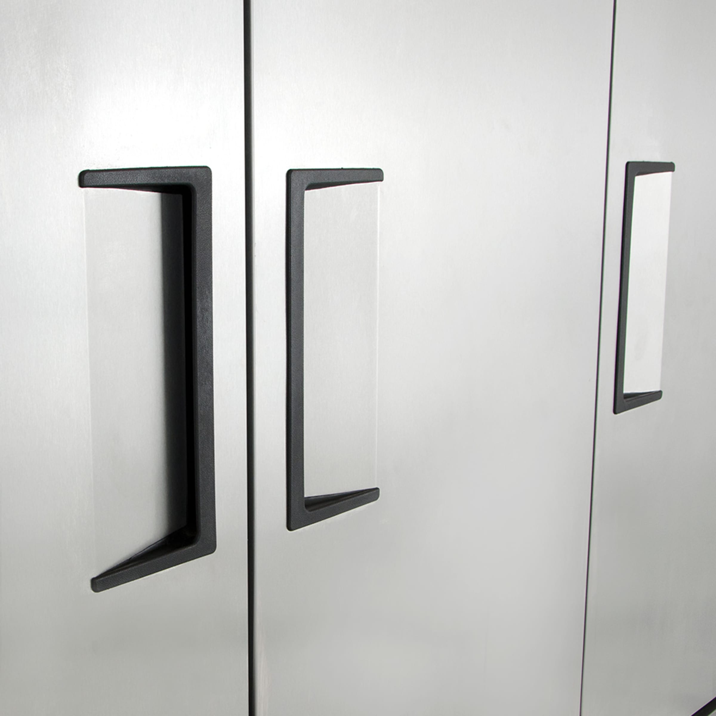 Close-up of recessed door handles on stainless refrigerator doors